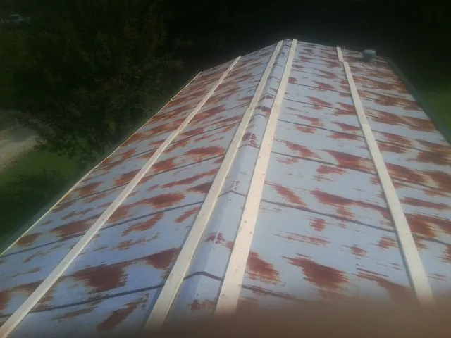 Rusted metal roof panels with new wood purlins before replacement — Storm Damage Roof Repair in Paonia by Roofing Brothers