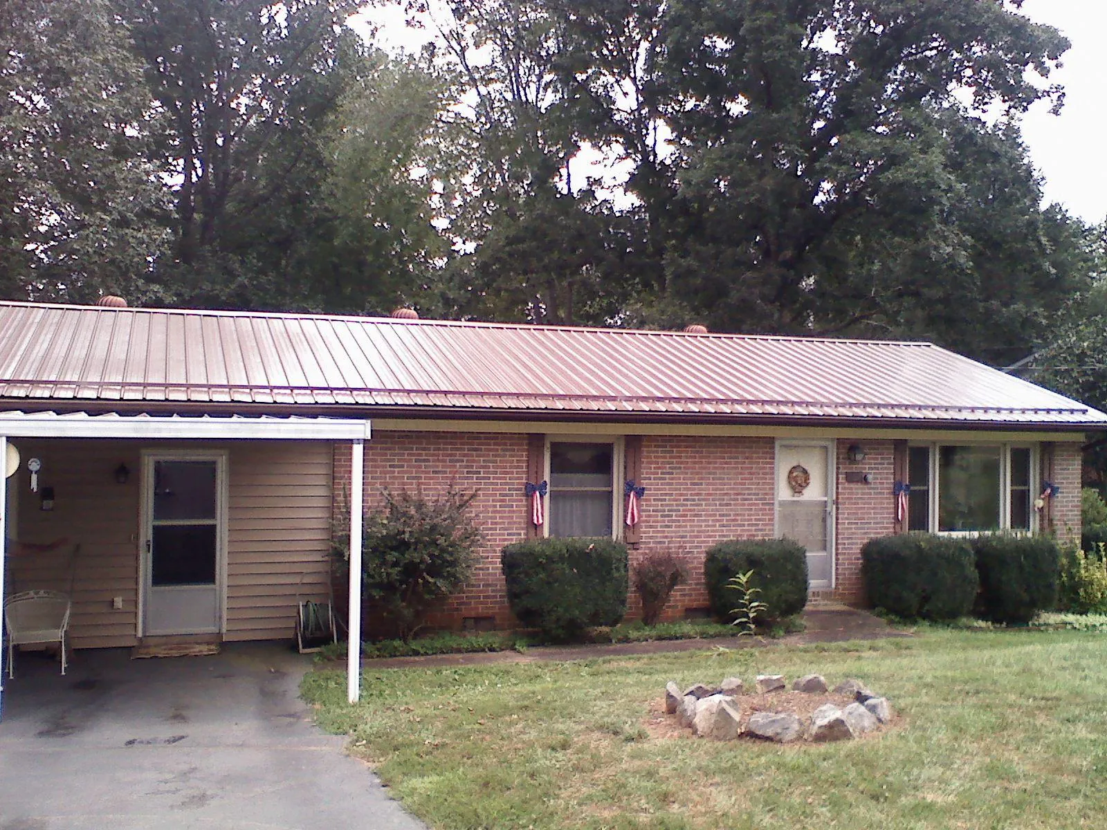 Bronze metal roof and carport on a brick ranch home — Roof Repair work by our crew in Paonia